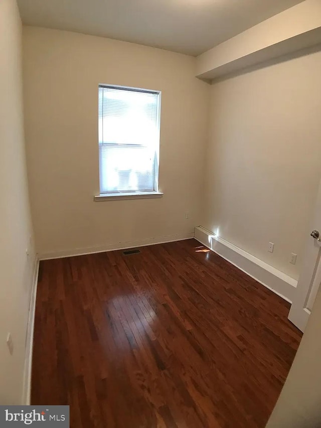 empty room with dark hardwood / wood-style flooring