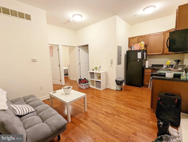 living room with electric panel and light hardwood / wood-style floors