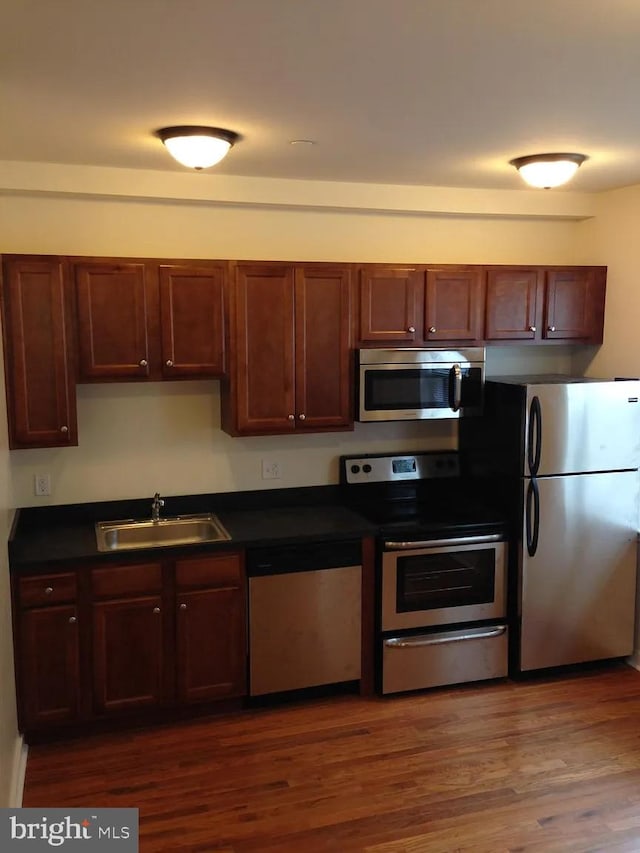 kitchen with dark hardwood / wood-style flooring, sink, and appliances with stainless steel finishes