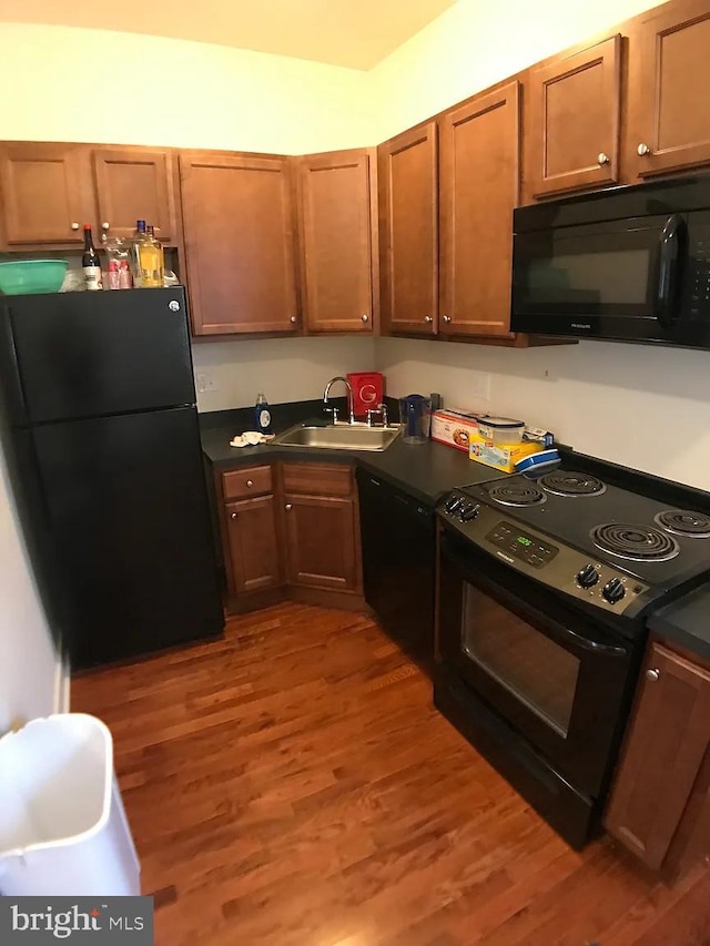 kitchen with hardwood / wood-style floors, sink, and black appliances