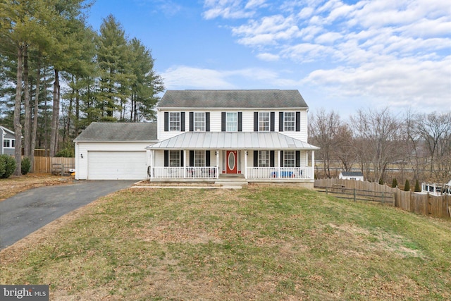 view of front of property with covered porch, a front yard, and a garage