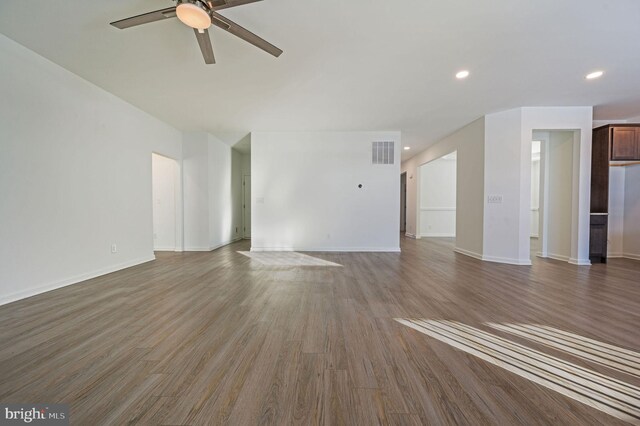 unfurnished living room featuring a ceiling fan, wood finished floors, visible vents, baseboards, and recessed lighting