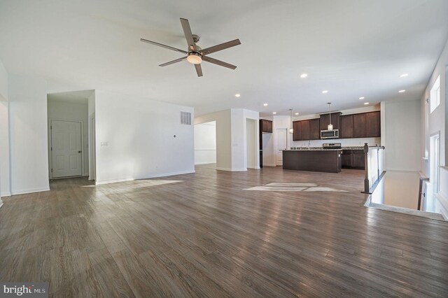 unfurnished living room with a ceiling fan, recessed lighting, dark wood-style floors, and baseboards