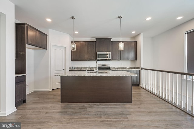 kitchen with recessed lighting, dark brown cabinets, appliances with stainless steel finishes, and wood finished floors