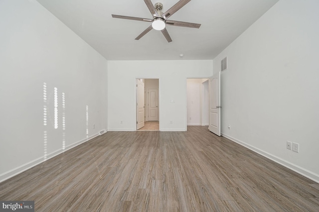 unfurnished bedroom with a ceiling fan, wood finished floors, visible vents, and baseboards