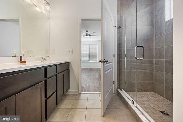 full bathroom with tile patterned flooring, a stall shower, vanity, and a ceiling fan