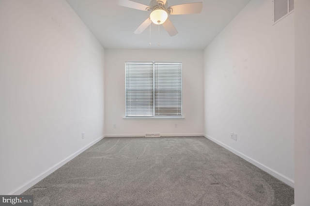 spare room with visible vents, carpet flooring, a ceiling fan, and baseboards