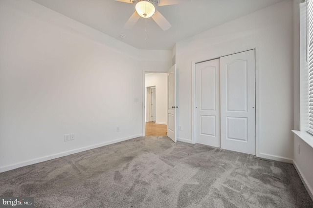 unfurnished bedroom featuring a closet, a ceiling fan, baseboards, and carpet floors