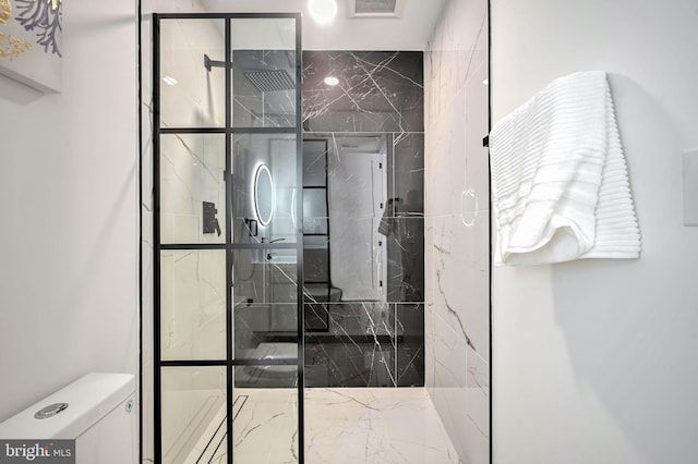 bathroom featuring toilet and a tile shower