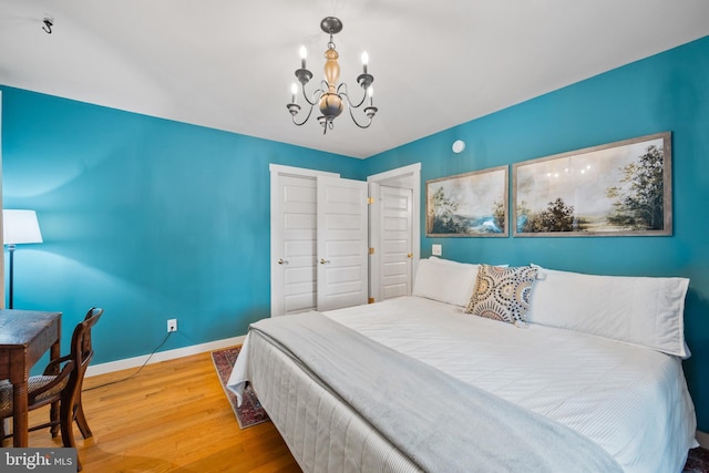 bedroom featuring a closet, wood-type flooring, and a notable chandelier