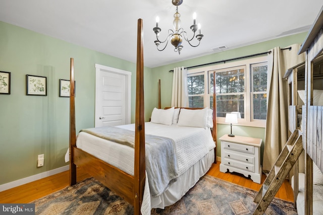 bedroom featuring light hardwood / wood-style flooring and a chandelier