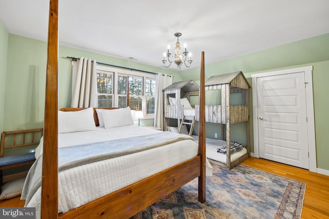 bedroom featuring wood-type flooring and an inviting chandelier