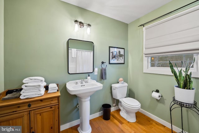 bathroom with hardwood / wood-style flooring and toilet