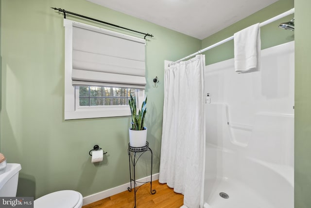 bathroom with toilet, hardwood / wood-style floors, and curtained shower