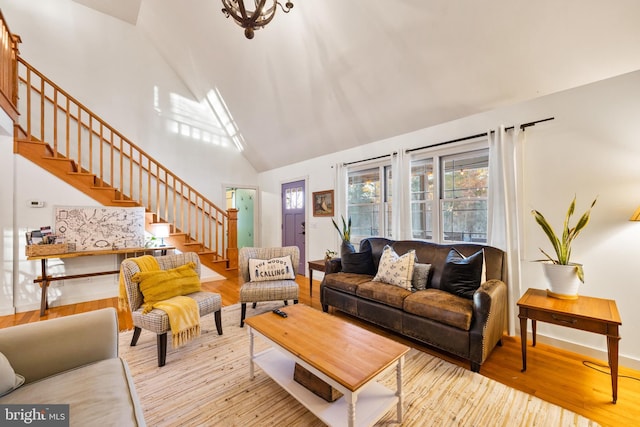 living room with high vaulted ceiling and light wood-type flooring