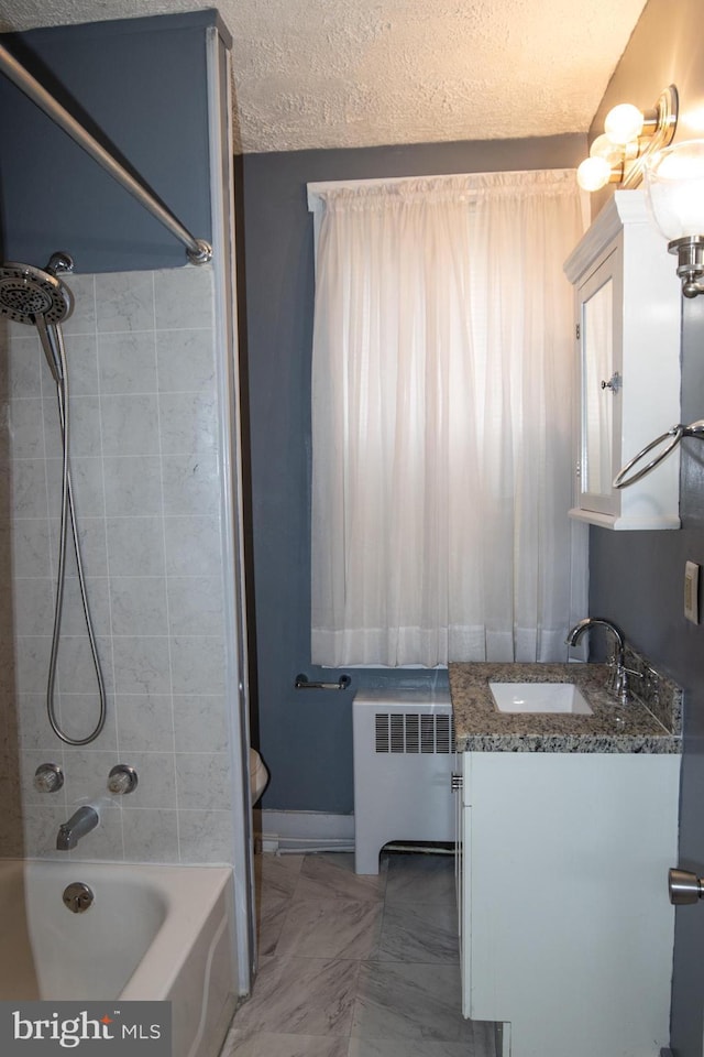 full bathroom with radiator heating unit, tiled shower / bath combo, a textured ceiling, toilet, and vanity