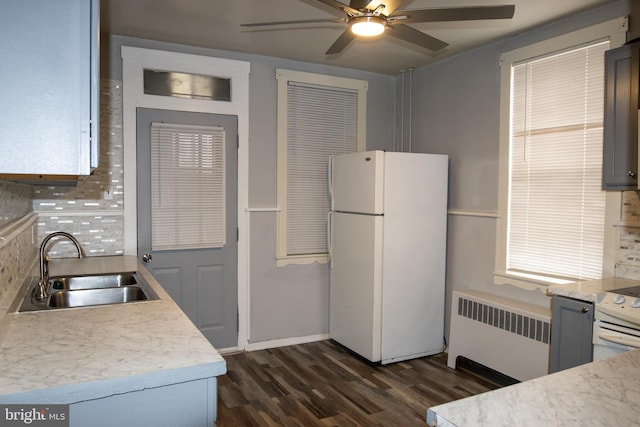 kitchen with tasteful backsplash, ceiling fan, sink, white refrigerator, and radiator heating unit