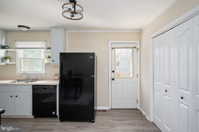 kitchen with sink, light hardwood / wood-style floors, white cabinetry, and black appliances