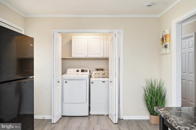 clothes washing area with washer and clothes dryer, light hardwood / wood-style floors, cabinets, and ornamental molding