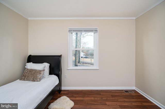 bedroom with dark hardwood / wood-style floors and ornamental molding