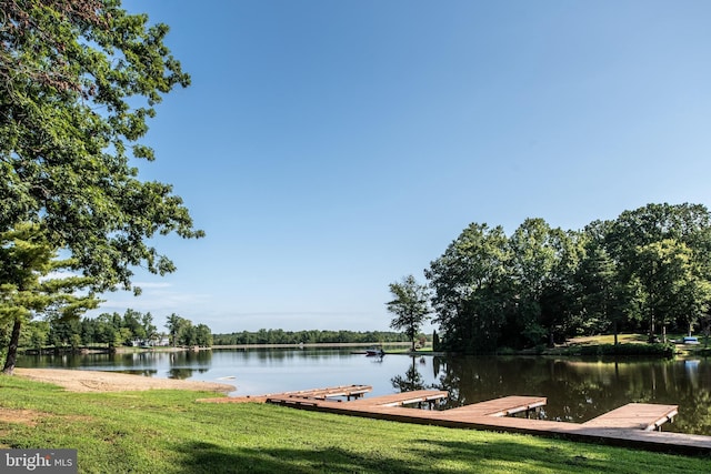 dock area with a yard and a water view