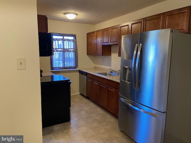 kitchen featuring sink, a textured ceiling, and appliances with stainless steel finishes