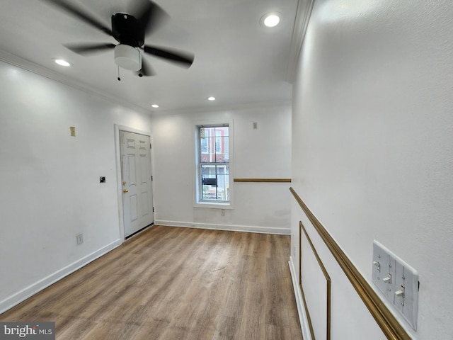 spare room with ceiling fan, light wood-type flooring, and ornamental molding