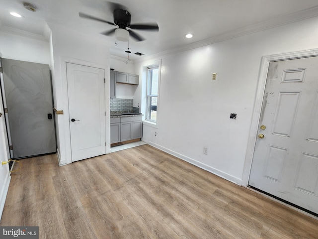 interior space with ceiling fan, light hardwood / wood-style flooring, and crown molding