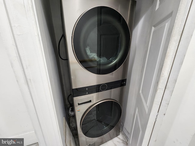 washroom featuring stacked washer / drying machine