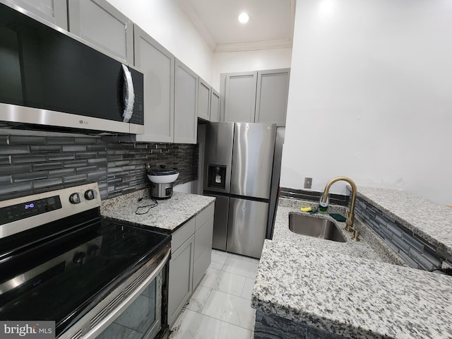 kitchen featuring light stone countertops, appliances with stainless steel finishes, gray cabinetry, and sink