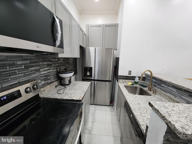 kitchen featuring backsplash, sink, light stone countertops, and stainless steel appliances