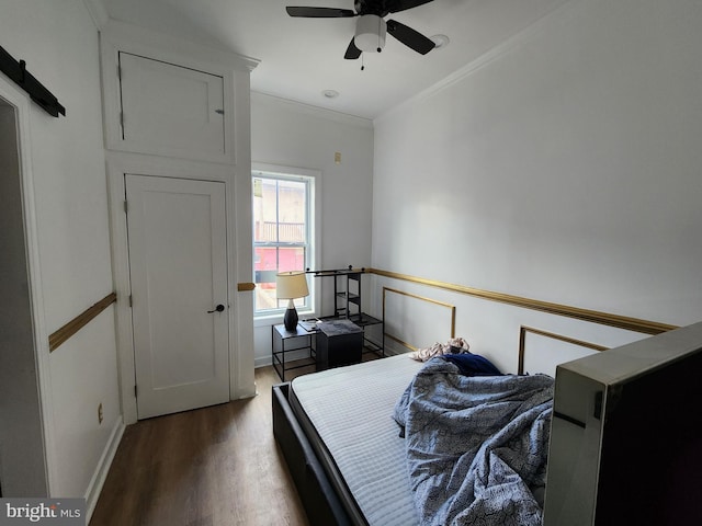 bedroom with hardwood / wood-style floors, ceiling fan, and ornamental molding