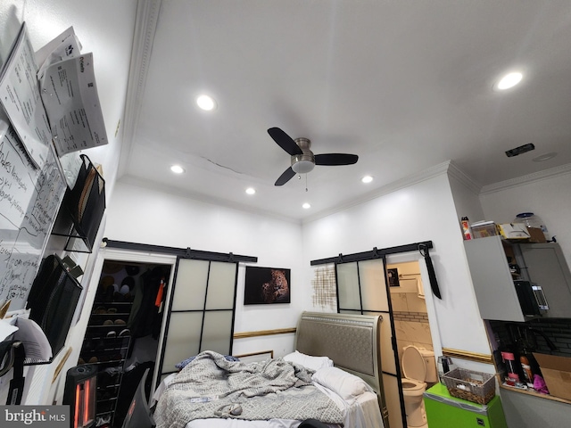 bedroom with a barn door, ceiling fan, a closet, and ornamental molding