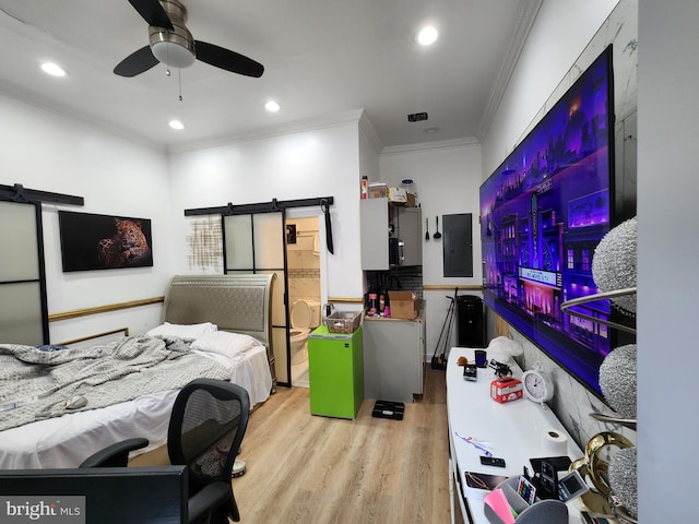 bedroom with ceiling fan, a barn door, ornamental molding, electric panel, and light wood-type flooring