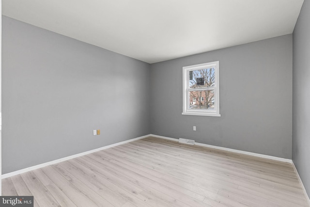 empty room with light hardwood / wood-style flooring