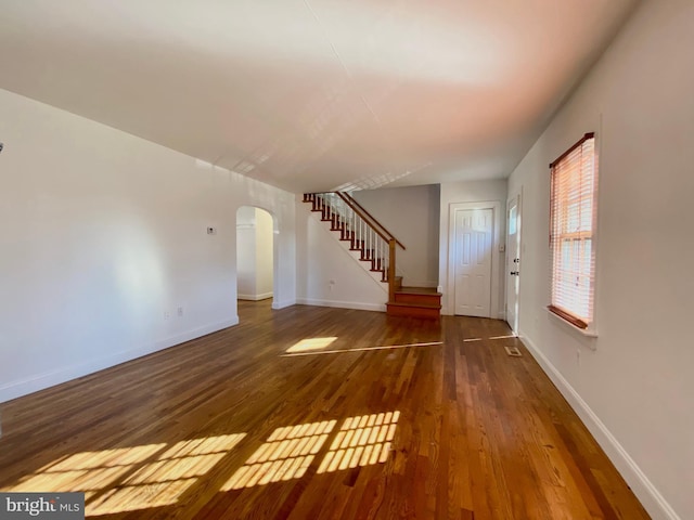 unfurnished living room with dark hardwood / wood-style flooring