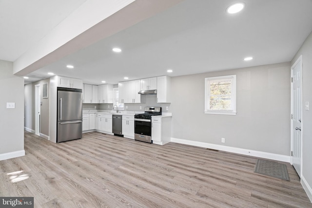 kitchen with white cabinets, sink, appliances with stainless steel finishes, and light hardwood / wood-style flooring