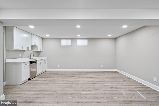 kitchen featuring white cabinets, light wood-type flooring, stainless steel dishwasher, and sink