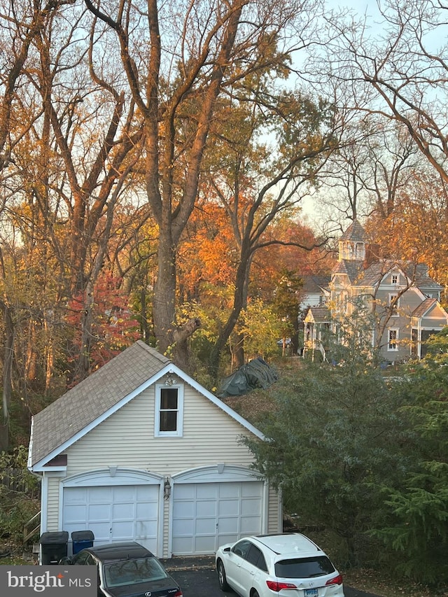 exterior space featuring a garage and an outbuilding