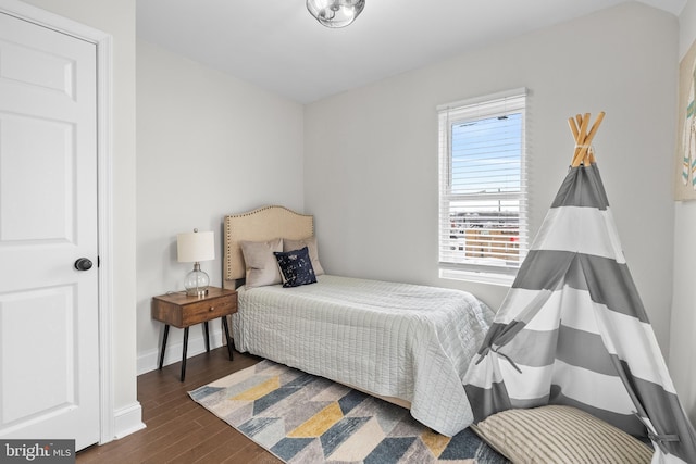 bedroom with dark hardwood / wood-style flooring