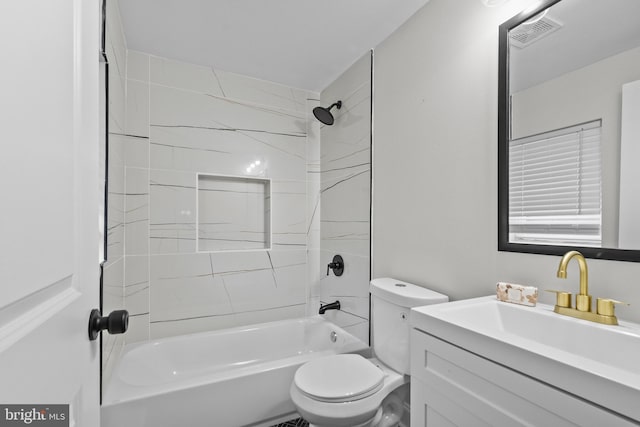 full bathroom featuring vanity, tiled shower / bath combo, and toilet