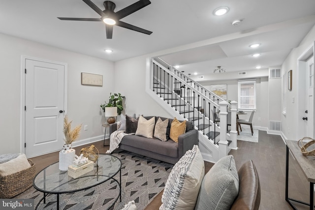 living room featuring ceiling fan and dark wood-type flooring