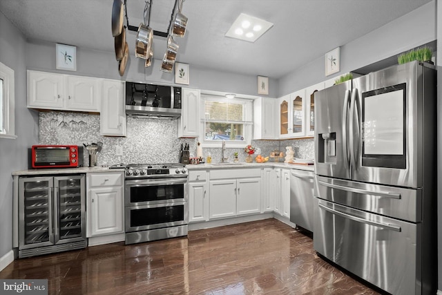 kitchen featuring sink, white cabinetry, appliances with stainless steel finishes, and wine cooler