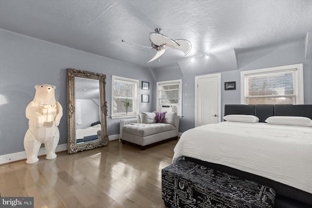 bedroom with ceiling fan, wood-type flooring, a textured ceiling, and cooling unit