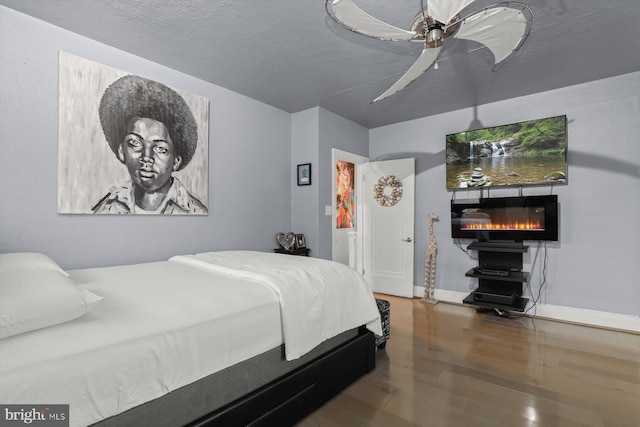 bedroom featuring a textured ceiling, ceiling fan, and hardwood / wood-style floors