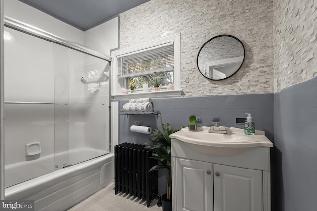 bathroom featuring enclosed tub / shower combo, tile patterned flooring, vanity, and radiator heating unit