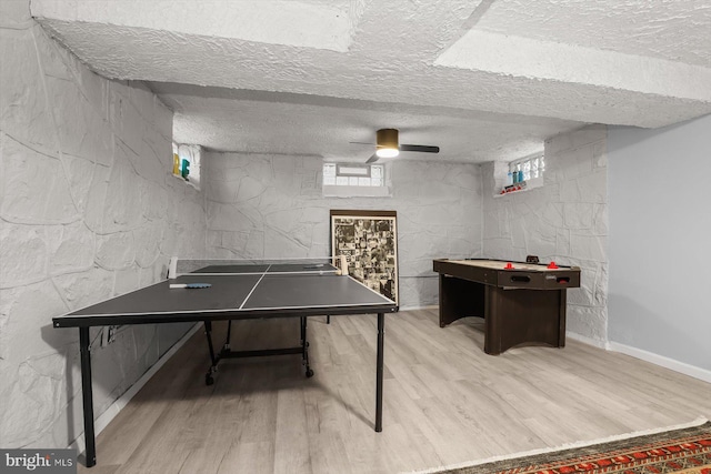 rec room featuring light hardwood / wood-style floors and a textured ceiling