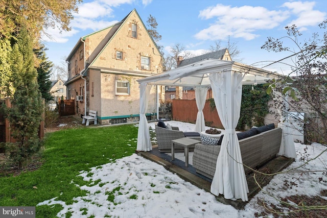 snow covered house with a gazebo and a lawn