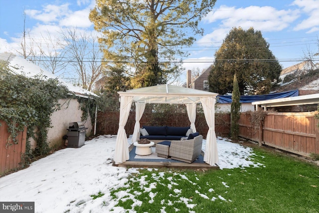 yard layered in snow featuring a gazebo and an outdoor living space