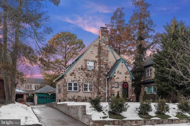 tudor house featuring a garage and an outdoor structure